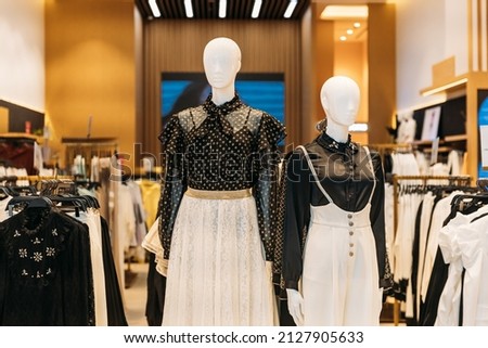 Female mannequin in store mall market. Fashion clothes - blouse, skirt. Mannequins dressed in female woman fashion clothes in store of shopping center. Clothes on hangers in store of shopping center.