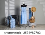 Female mannequin with stylish light blue dress and other clothes indoors