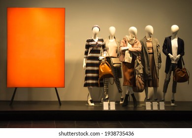 Female mannequins near red stand. Standing dummies in spring autumn or winter clothes. Shop window clearance. Women shopping