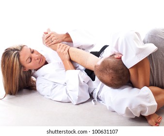 Female martial artist demonstrating a choke hold on white background