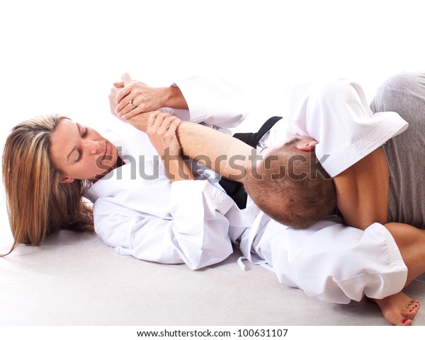 Female martial artist demonstrating a choke\
hold on white background