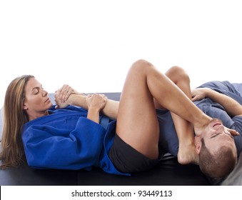 Female martial artist submitting an opponent with a dual armbar foot choke
