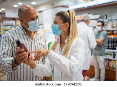 Female Masked Young Clerk Serving A Customer In A Small Store, Shopping During Covid Or Coronavirus Concept