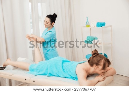 Female masseur doing therapeutic medical foot massage in spa