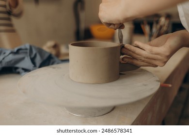 Female master paints a pot, pottery workshop - Powered by Shutterstock