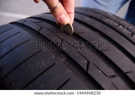 Female Measuring tire depth using a small coin