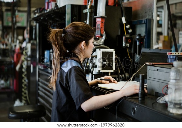 Female mechanic analysing\
the report