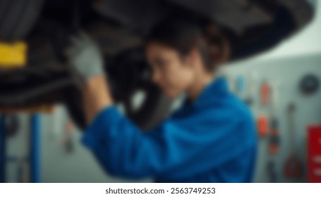 A female mechanic in blue overalls working under a car in a garage, emphasizing skill and gender diversity in automotive repair - Powered by Shutterstock