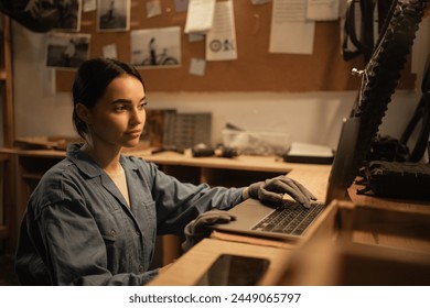 Female mechanic checking data on a laptop in a workshop during servicing or bike repair in garage. Copy space - Powered by Shutterstock