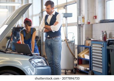  female mechanic with a customer checking a car breakdown on a laptop - Powered by Shutterstock