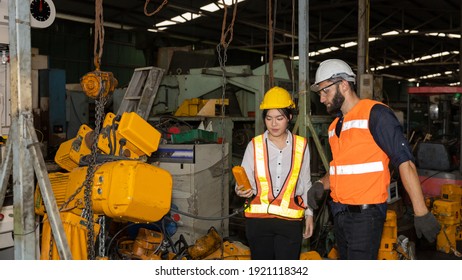 Female Mechanic Engineer Or Worker With Hardhat And Safety Gears Is Working With Her Supervisor In A Factory Checking The Function Of A System