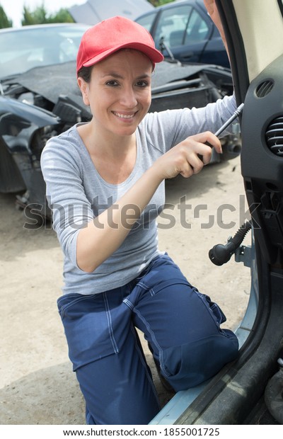 female mechanic fixing a car\
door