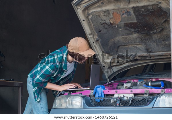 Female mechanic fixing\
car  in a garage