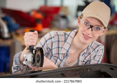 female mechanic grinding body car - Powered by Shutterstock