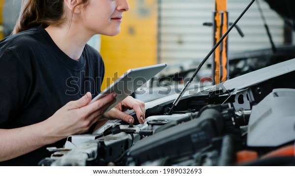 Female\
mechanic running a diagnostic on a car\
engine