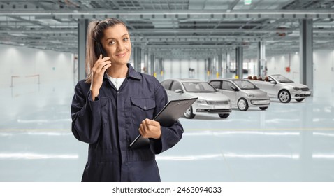 Female mechanic using a smartphone inside a car garage - Powered by Shutterstock