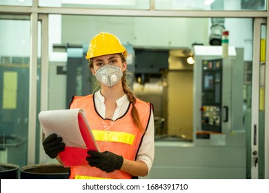 Female Mechanic wearing  protective mask to Protect Against Covid-19,Female technician worker working and checking machine in a large industrial factory,Coronavirus has turned into a global emergency - Shutterstock ID 1684391710