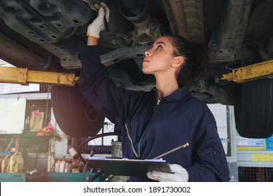 Female mechanic work in garage, car service technician woman checking and repairing customer’s car at automobile service center, inspecting car underbody and suspension system, vehicle repair service - Powered by Shutterstock