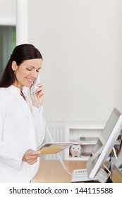 Female Medical Assistant Answers Phone Call At Reception