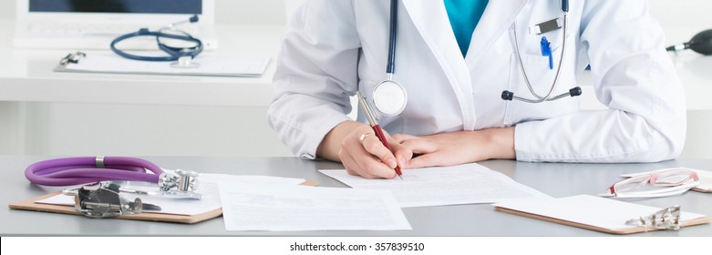 Female Medical Doctor Writing Something Sitting At Her Office. Healthcare And Medical Concept.. Letter Box Format