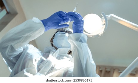 A female medical officer wearing PPE is preparing a syringe. - Powered by Shutterstock