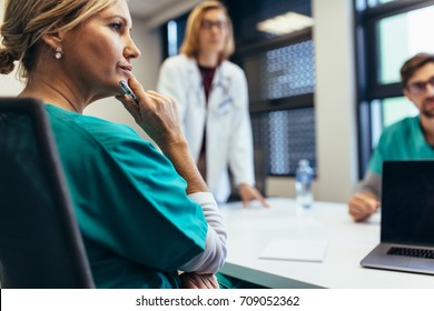 Female medical professional in meeting with colleagues. Doctor during meeting in the conference room.