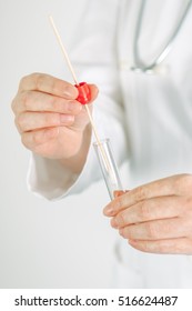 Female Medical Specialist Holding Buccal Cotton Swab And Test Tube, Ready To Collect DNA From The Cells On The Inside Of A Person's Cheek.