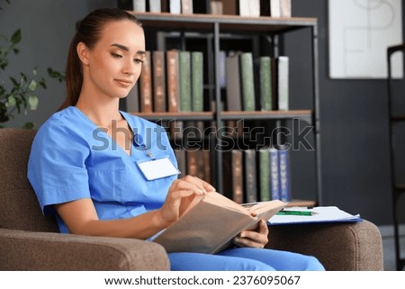 Female medical student reading book in library