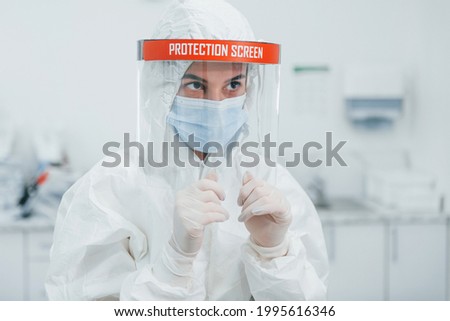 Female medical worker in protective uniform works on COVID-19 vaccine.