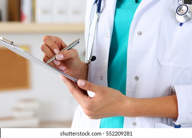 Female medicine doctor hand holding silver pen writing something on clipboard closeup. Medical care, insurance, prescription, paper work or career concept. Physician ready to examine patient and help
