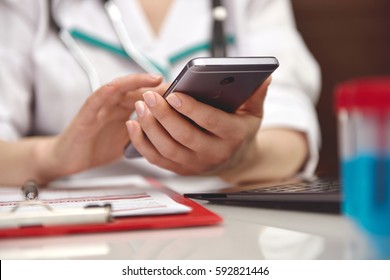 Female Medicine Doctor Holding Mobile Smart Phone. Close Up