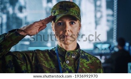 Female Military Officer Giving Salute Gesture in Front of the Camera. She in Standing in Surveillance Cyber Operations Office for Managing National Security, Technology and Army Communications.