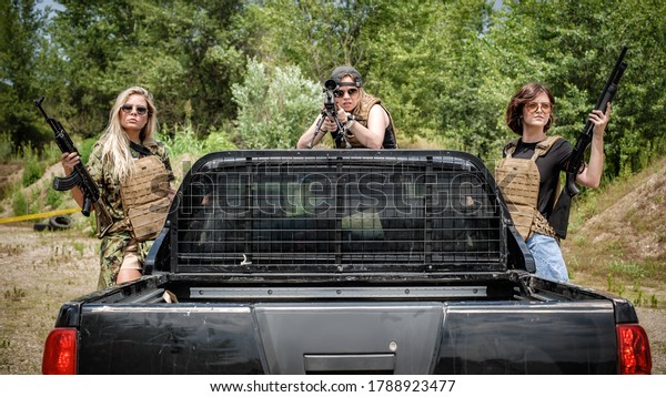 Female military security team with their jeep car,\
ready for defensive action. Shotgun, rifle and sniper. Woman with\
weapon