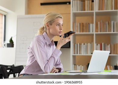 Female Millennial Employee Recording Audio Message On Smartphone While Working In Office. Cellphone User Using Voice Recognition App, Activating Virtual Assistant, Talking To Speaker Of Mobile Phone