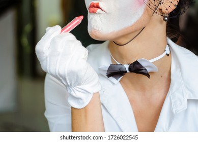 A Female Mime Comedian Portrays Painting Her Lips