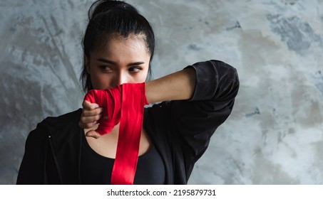 A female mixed martial artist is wrapped in a red boxing bandage. Strong hands ready for close combat, exercise and sparring. Women's self-defense. - Powered by Shutterstock