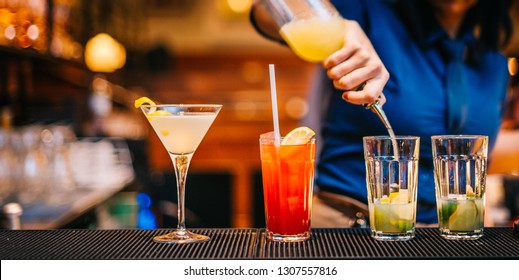 Female Mixologist Bartender At Work Preparing Making Serving Alcoholic Drinks Cocktails On Counter Top In Night Club Party