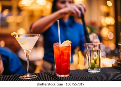 Female Mixologist Bartender At Work Preparing Making Serving Alcoholic Drinks Cocktails On Counter Top In Night Club Party