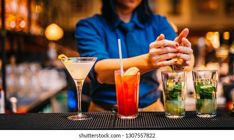 Female Mixologist Bartender At Work Preparing Making Serving Alcoholic Drinks Cocktails On Counter Top In Night Club Party