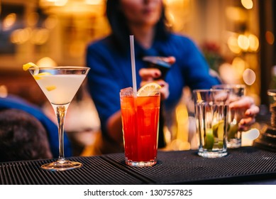 Female Mixologist Bartender At Work Preparing Making Serving Alcoholic Drinks Cocktails On Counter Top In Night Club Party