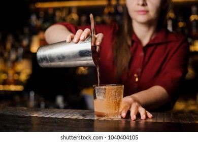 Female Mixologist Pouring A Fresh Drink From Shaker Into A Cocktail Glass Decorated With Cinnamon