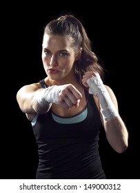 Female MMA Fighter Punching.  Black Background