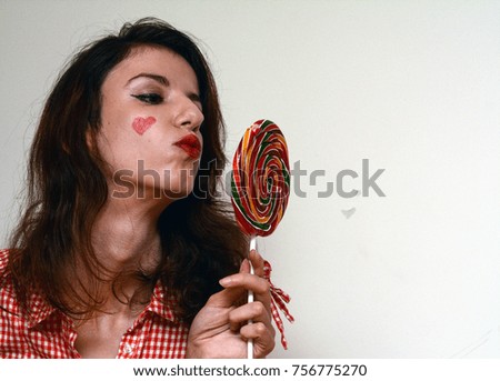 Female model enjoying a colorfull lollipop