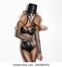 Female model in Halloween. Sexy woman in top hat and skull make up. Halloween costume concept.