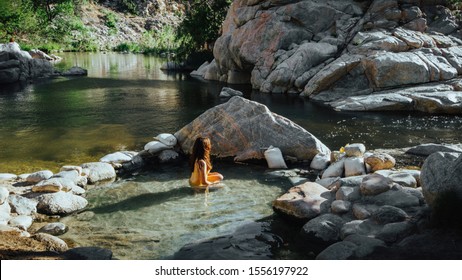 Female model relaxing in hot springs at the Deep Creek Hot Springs in California, USA.