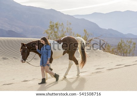 A female model riding her horse through the Mohave Desert