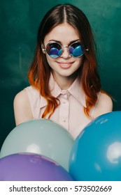 Female model in sunglasses with colored balls in his hands