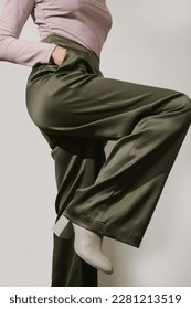 Female model wearing tight viscose long sleeved top and wide green satin trousers. Classic, simple, comfortable yet stylish fashion. Studio shot.	 - Shutterstock ID 2281213519
