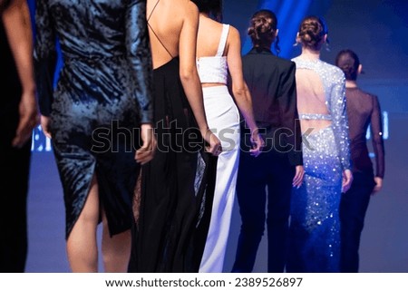 Female models present new creation on the runway from autumnwinter collection during fashion week show. From model's backs.