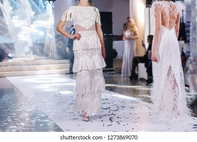 Female Models Walk The Runway In Beautiful Stylish White Wedding Dresses During A Fashion Show. Catwalk Event Showing New Collection Of Clothes.